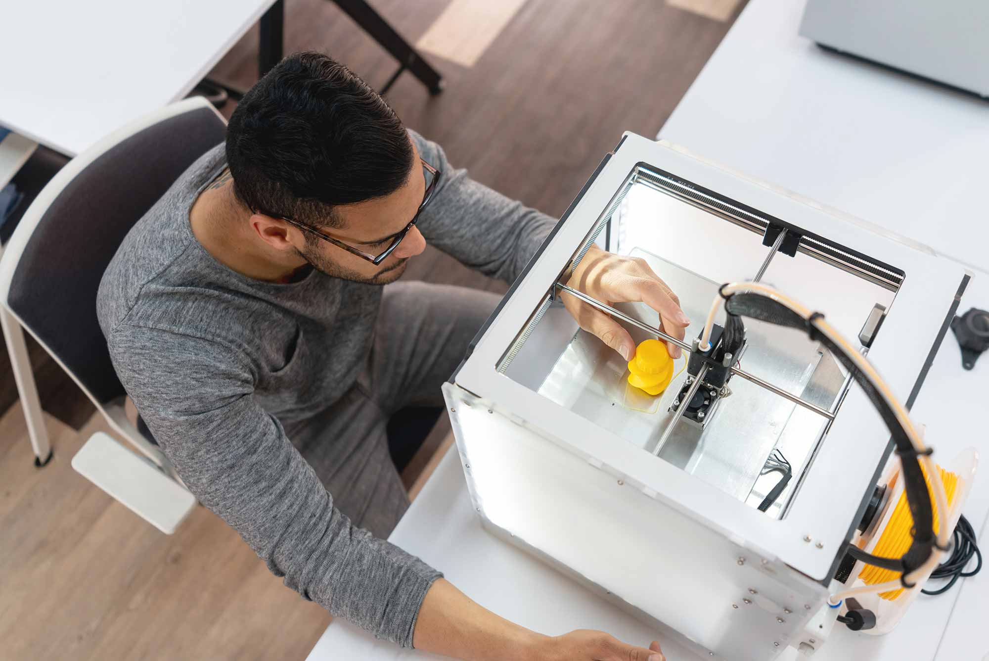 Portrait of a student using a 3D printer at a workshop. 