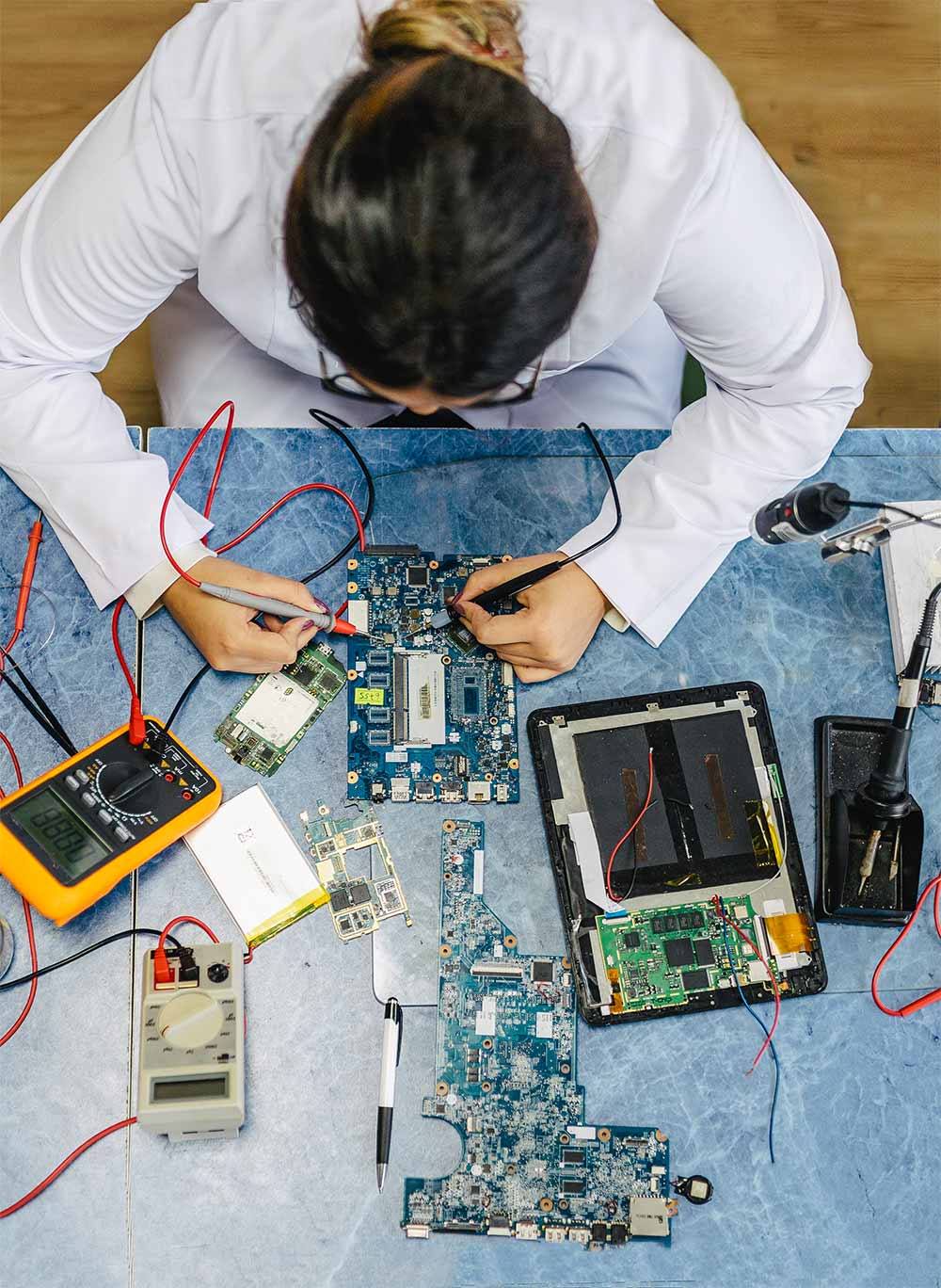 Female electronic engineer testing computer motherboard in laboratory 