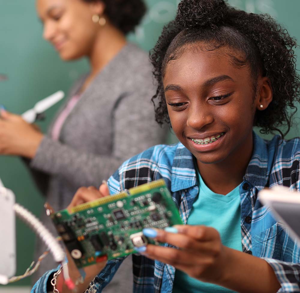 Junior high school age school students build robot in technology, engineering class. 